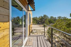 a balcony of a house with glass doors at Hill Country Norwood Tiny Home B- Sits on 13 Acres, Sleeps 2 and Pet Friendly! in Dripping Springs