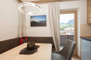 a dining room with a table and chairs and a window at Familienappartement Seenland in Reith im Alpbachtal
