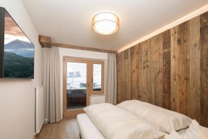 a bedroom with a white bed and a window at Familienappartement Seenland in Reith im Alpbachtal