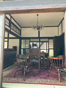 een eetkamer met een tafel en stoelen en een kroonluchter bij Kominkahaku Takenoko - Vacation STAY 45999v in Hita