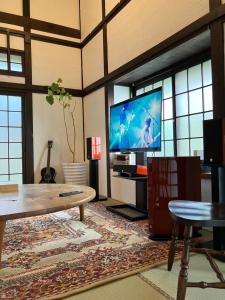 sala de estar con TV grande y mesa en Kominkahaku Takenoko - Vacation STAY 45999v en Hita