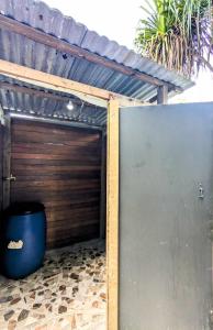 a garage with a wooden door and a blue barrel at ALAROOTS BORA BORA CAMP in Bora Bora