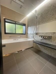 uma casa de banho com uma banheira, um lavatório e uma janela em Kominkahaku Takenoko - Vacation STAY 45999v em Hita