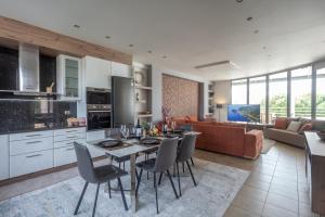 uma cozinha e sala de estar com mesa e cadeiras em LINA'S LUXURY APARTMENT em Loutraki