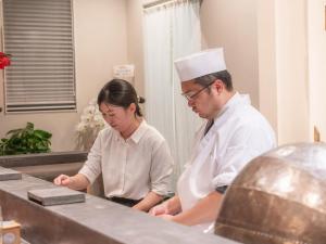 a man and woman in a kitchen preparing food at SWEET VILLA TAKASAMA2 - Vacation STAY 11608v in Fujiyoshida