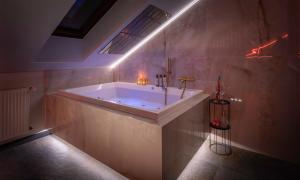 a large bathroom with a tub with lights on it at Exclusive BDSM Apartment Kraków - ADULTS ONLY in Krakow