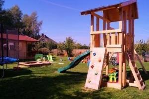 a playground with a wooden play structure in a yard at Villa Amber - b43068 in Gąski