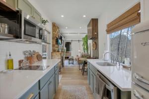 a kitchen with white counters and a large window at The Hillside Retreat - Tiny Home in Hocking Hills in Logan
