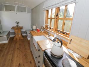 una cucina con bollitore per tè sul piano cottura di Shepherds Hut at Lythwood a Shrewsbury