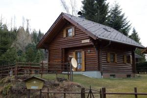 a small wooden cabin with a fence in front of it at Ferienhaus Stoakoglhütte in Klippitztörl in Klippitztorl