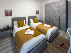 a bedroom with two beds with yellow and white sheets at [Elegant Apartment] Airport 5min • A/C • Disney+ in Genova