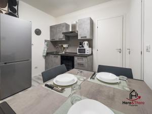 a kitchen with a table with chairs and a refrigerator at [Elegant Apartment] Airport 5min • A/C • Disney+ in Genova