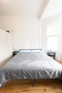 a large bed in a white room with two tables at Close to NYC - Stylish Modern Studio in Union City