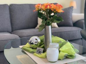 - un vase avec des fleurs sur une table dans le salon dans l'établissement Luxusfewo mit 2 Schlafzimmern, Boxspringbett, IR-Wärmekabine für bis zu Vier, à Goslar