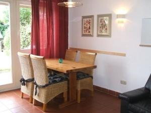 comedor con mesa de madera y sillas en Ferienhäuser Schlossberg mit zwei sep Schlafräumen, kostenlosem w-lan und neuer Hausausstattung - b48525, en Zandt