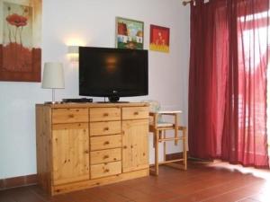 TV en un tocador de madera en la sala de estar en Ferienhäuser Schlossberg mit zwei sep Schlafräumen, kostenlosem w-lan und neuer Hausausstattung - b48525, en Zandt