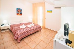 a bedroom with a bed and a flat screen tv at Hotel Fernanda in Letojanni