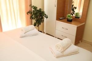 Dos toallas sentadas en una cama en un dormitorio en Gusto Hotel en Ksamil