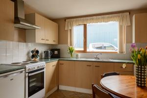 a kitchen with a table and a sink and a window at Grove Fort Self Catering Farmhouse in Finnis