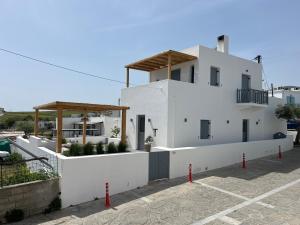 a white house with a parking lot in front of it at Sorokos House in Dhragoulás