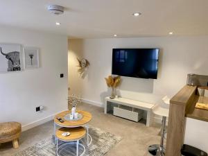 a living room with a flat screen tv on the wall at Modern 2 bedroom Flat in Montrose in Montrose +8 photos