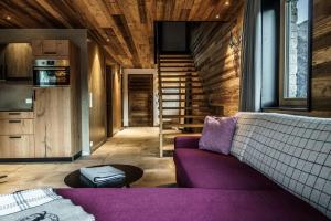 a living room with a purple couch and stairs at Ferienwohnungen direkt an der Skiabfahrt und MTB-Trails - b57507 in Sölden