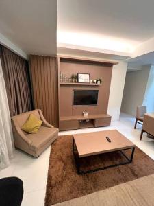 - un salon avec un canapé et une télévision dans l'établissement Monarch Suites at Padgett Cebu w/ pool near Ayala, à Cebu