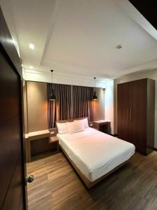 - une chambre avec un grand lit blanc dans l'établissement Monarch Suites at Padgett Cebu w/ pool near Ayala, à Cebu
