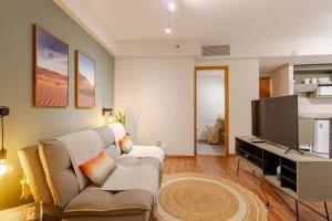 ein Wohnzimmer mit einem Sofa und einem Flachbild-TV in der Unterkunft Quarto Comfort coração de Alphaville Piscina e Academia in Barueri