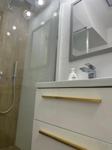 a bathroom with a shower and a sink and a mirror at Blisko Neptuna in Gdańsk