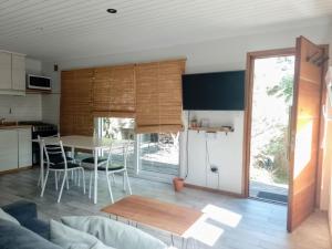 a kitchen and living room with a table and chairs at La Escondida in Valeria del Mar