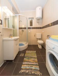 a bathroom with a sink toilet and a washing machine at Apartmani Nika Marangun in Dubrovnik