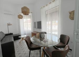 La Llave de la Corredera في قرطبة: غرفة معيشة مع طاولة وكراسي زجاجية
