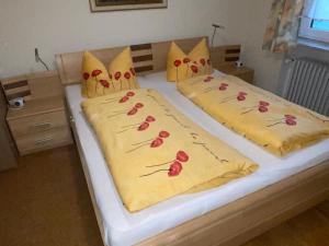 a bedroom with two beds with red roses on them at Ferienwohnung bis 6 Pers 1OG in Zandt