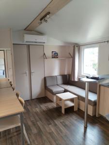 Boofzheim的住宿－Mobil-Home 6 personnes avec clim N' B025，带沙发和桌子的小客厅