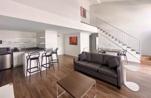 a living room with a couch and a table and a kitchen at Hotel Lac Brome in Lac-Brome