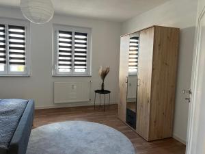 ein Schlafzimmer mit einem großen Holzschrank und Fenstern in der Unterkunft Stadtvilla in Hechingen in Hechingen