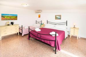 a bedroom with a large bed and two dressers at Hotel Fernanda in Letojanni