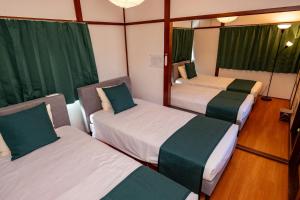 2 Betten in einem Zimmer mit grünen Vorhängen in der Unterkunft Satorie Beppu - Vacation STAY 19669v in Beppu
