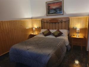 a bedroom with a large bed with two lamps on tables at Casa Roseta in Deltebre