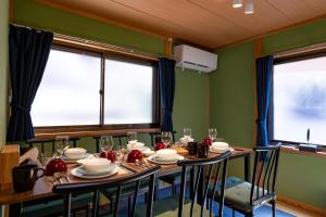 uma sala de jantar com uma mesa e duas janelas em Satorie Beppu - Vacation STAY 19669v em Beppu