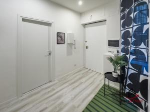 un corridoio con una porta, una sedia e una pianta di [Elegant Apartment] Airport 5min • A/C • Disney+ a Genova