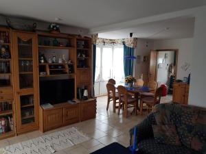 a living room with a table and a television at Ferienhaus in Neßmersiel mit Großer Terrasse in Dornum