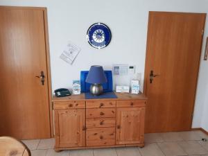 a wooden dresser with a lamp on top of it at Ferienhaus in Neßmersiel mit Großer Terrasse in Dornum +14 photos