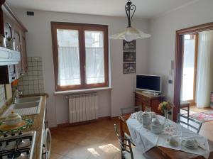 uma cozinha com uma mesa e uma televisão em Casa JaRi em San Giovanni Rotondo