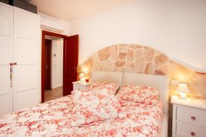 a bedroom with a bed with a floral bedspread at Villa Coclea con piscina in San Teodoro +23 photos