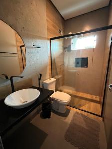 een badkamer met een wastafel, een toilet en een douche bij Pousada Vila da Mata in Canaã dos Carajás