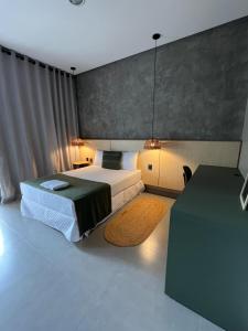 a bedroom with a bed and a table with a television at Pousada Vila da Mata in Canaã dos Carajás