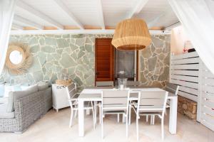 a dining room with a white table and chairs at Villa Coclea con piscina in San Teodoro