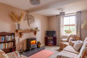 a living room with a fireplace and a couch at Grove Fort Self Catering Farmhouse in Finnis